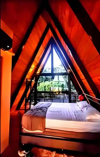 a bed in a room with a large window at Lakefront Chalet, hot tub, heated bathtub and waterfall in Alexânia