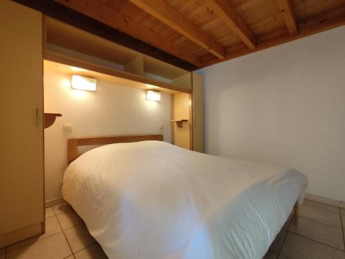 a white bed in a room with two lights at Village Vacances La Manne in Bormes-les-Mimosas