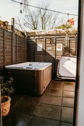 a bath tub sitting in the middle of a yard at Robyns Retreat in Brynsiencyn