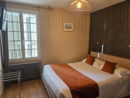 a bedroom with a large bed and a large window at La Route d'Argent in Bozouls