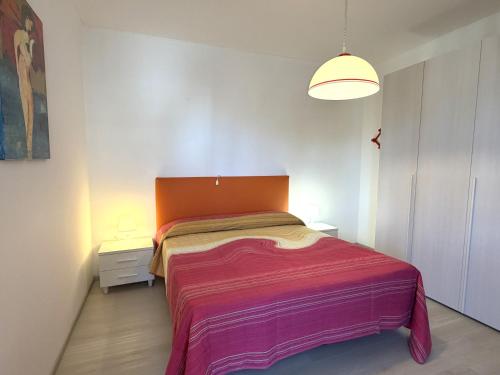 a bedroom with a large bed with an orange headboard at Appartamenti Oscar in Grado