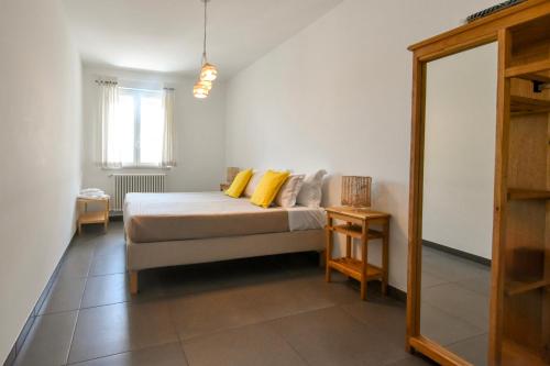 a bedroom with a bed with yellow pillows and a mirror at Levante Sea View Apartment - Housea in Polignano a Mare
