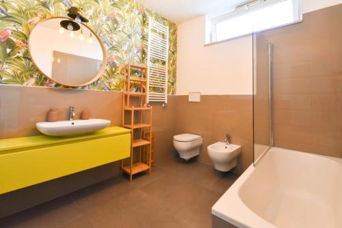 a bathroom with a sink and a toilet and a mirror at Levante Sea View Apartment - Housea in Polignano a Mare