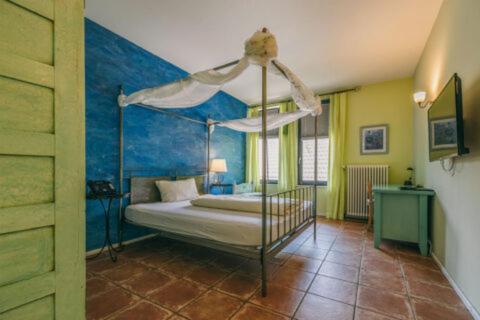 a bedroom with a canopy bed with a blue wall at Rosi's Dorfwirtschaft in Rottenacker