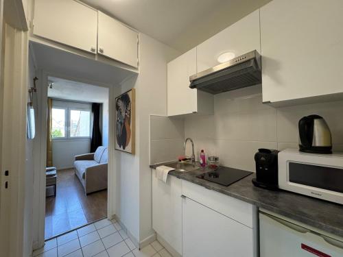 a kitchen with a sink and a microwave at Cosy studio centre-ville & RER A in Saint-Germain-en-Laye
