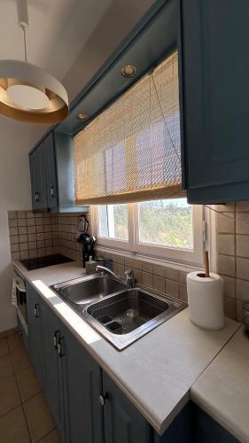 a kitchen with a sink and a window at Blue House Naxos in Naxos Chora