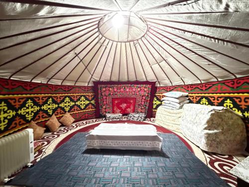 a room with a bed and pillows in a yurt at Bakytzhan hotel in Kurmenty