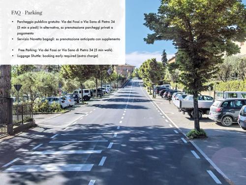 an empty street with a tree and parked cars at b&b BORGO CAPITANO COLLECTION Albergo diffuso, Village Experience - Centro Storico in San Quirico dʼOrcia
