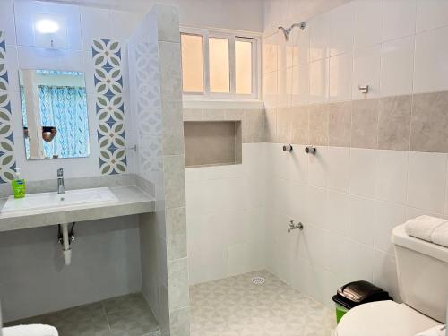 a white bathroom with a sink and a toilet at Departamento Arena- Oasis del Mar in Progreso