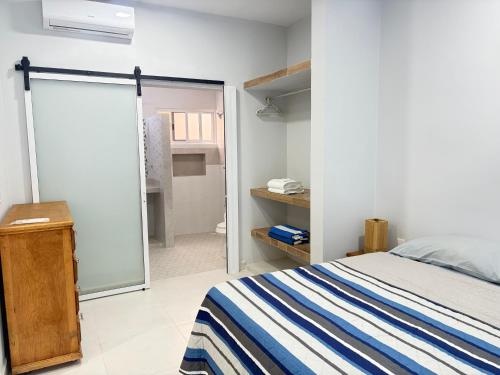 a bedroom with a bed and a sliding glass door at Departamento Arena- Oasis del Mar in Progreso