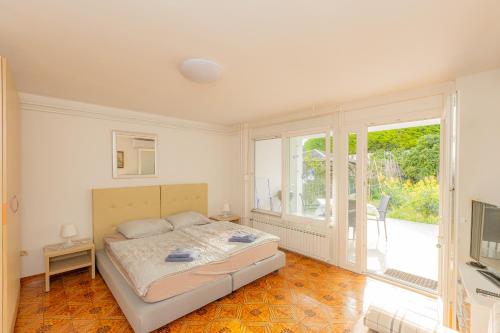 a bedroom with a bed and a large window at Apartments M&M Portorož in Lucija
