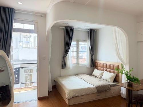 a bed in a room with a large window at Four P Home and Studio in Ho Chi Minh City