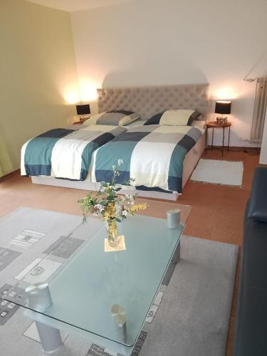 a bedroom with a large bed and a glass table at Vogelparadies Homestay Nichtraucher in Hemhofen