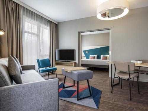 a living room with a couch and chairs and a bed at Aparthotel Adagio Glasgow Central in Glasgow
