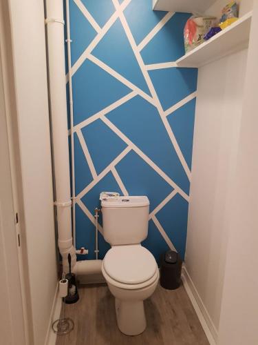 a bathroom with a toilet and a blue wall at Casino in Dieppe