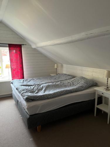 a bedroom with a large bed with a red window at Gästhus i Västanbyn, Sandviken in Sandviken