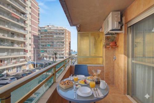 a balcony with a table with food and drinks on it at Apartamento en Cullera in Cullera