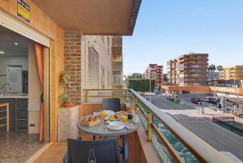 a table on a balcony with a view of a city at Apartamento en Cullera in Cullera