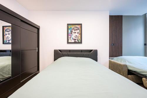 a bedroom with a bed and a cabinet and two beds at Le Belmondo Grand Studio in Moutiers