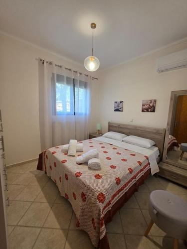 a bedroom with a bed with towels on it at Christos Sunhaven Apartment in Agia Ermioni