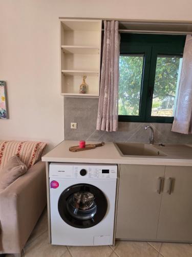 a kitchen with a washing machine and a sink at Christos Sunhaven Apartment in Agia Ermioni
