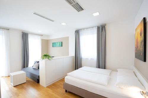 a white bedroom with a bed and a window at SHOME Hotel Graz I Self-Check-In I Free Parking in Graz