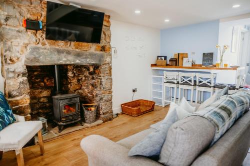a living room with a couch and a fireplace at Pauls Place in Brynsiencyn
