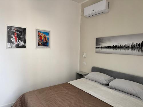 a bedroom with a bed and pictures on the wall at Living Room Orlando in Corigliano Calabro