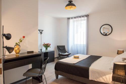 a bedroom with a bed and a desk and chairs at Occitanie Aquitaine gîte 5 pers -SPA privé-CLIM- Draps, vélos inclus - Equipé pour bébé in Soturac