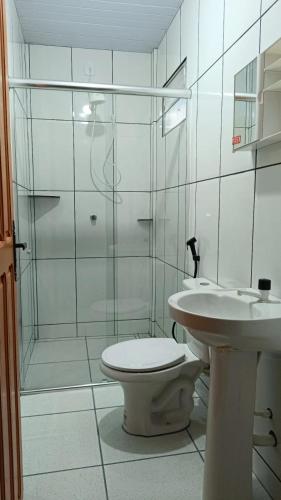 a white bathroom with a toilet and a sink at Hotel Star Rio in Novo Airão