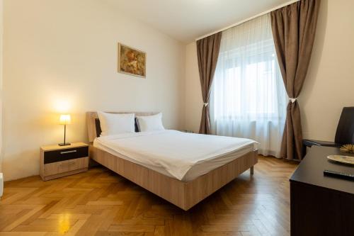 a bedroom with a large bed and a window at Schiller Apartment - Old Town in Sibiu