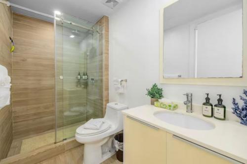 a bathroom with a toilet and a sink and a shower at Glamorous and modern beach apartment Eagle beach ARUBA in Savaneta