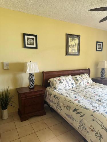 a bedroom with a bed and a table with a lamp at Mediterranean Caribbean View Village in Buena Vista