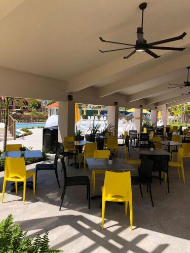 a restaurant with yellow chairs and tables and a ceiling at Mediterranean Caribbean View Village in Buena Vista