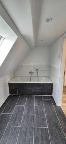 a bathroom with a bath tub in a attic at Ferien- & Monteurwohnung Stößen in Stößen