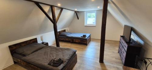 a bedroom with a bed and a tv in a attic at Ferien- & Monteurwohnung Stößen in Stößen