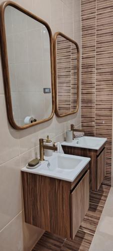 a bathroom with two sinks and a large mirror at Altitud 620 Boutique Suites in Nazca