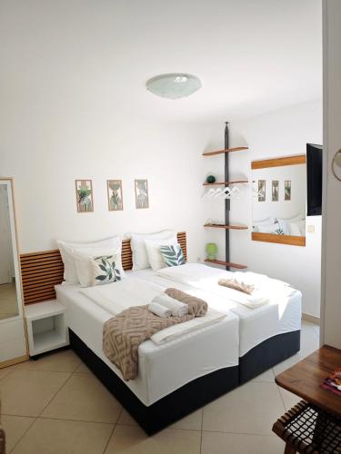 a white bedroom with two beds and a television at Apartments Mare in Hvar