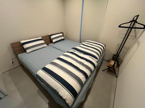 a bed with two striped pillows in a room at Laina Kai in Sumoto