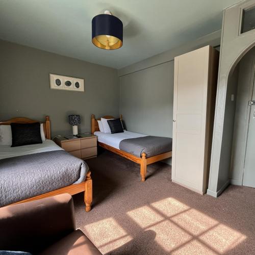 a bedroom with two beds and a lamp and a window at Smugglers Hotel in Brixham