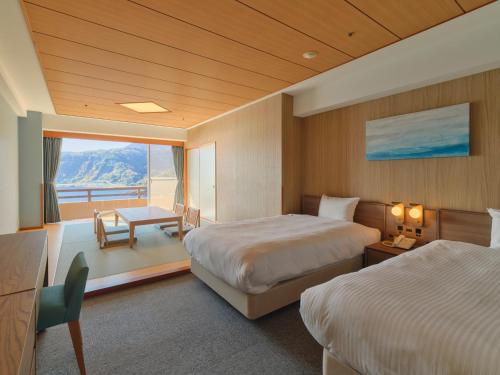 a hotel room with two beds and a balcony at Pleasure Resort Izu Akazawa Onsen in Ito