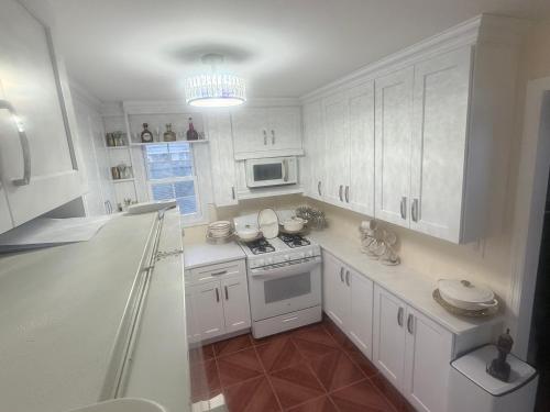 a kitchen with white cabinets and a stove top oven at Casseus J Legacy in Rosedale