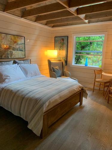 ein Schlafzimmer mit einem großen Bett und einem Fenster in der Unterkunft Mayne Cottage in Mayne Island