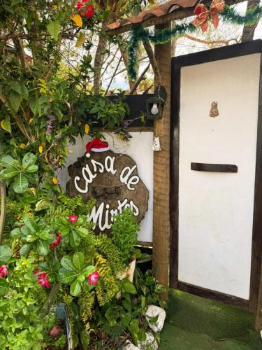 a door with a sign that reads quanta be miracles at Casa de Mirtes in Fernando de Noronha