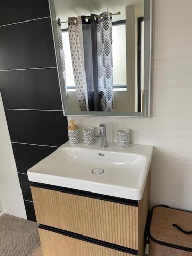 a bathroom with a sink and a mirror at La maison du bois brulée 5 in Villaines-les-Rochers