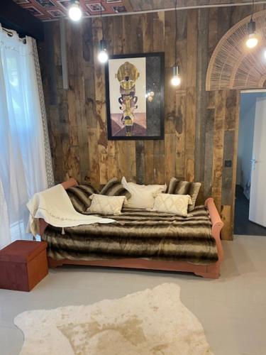 a living room with a couch in front of a wall at La maison du bois brulée 5 in Villaines-les-Rochers