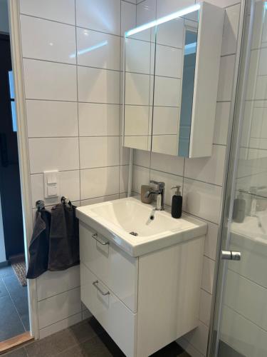 a white bathroom with a sink and a mirror at Tunneberga 1 65 in Jonstorp