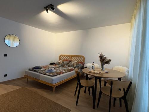 a bedroom with a bed and a table and a table and chairs at AuszeitOase inkl Oberstaufen Plus Karte in Oberstaufen