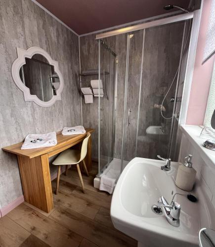 a bathroom with a desk and a sink and a shower at Smugglers Hotel in Brixham