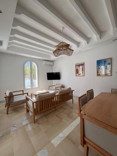 a living room with a couch and a tv at Dar Lisa - Charming authentic beachfront villa in Aghīr